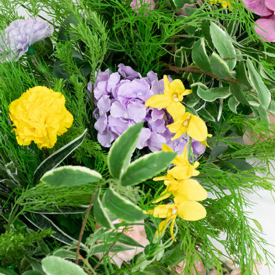Colorful mixed flower bouquet with purple, yellow, and green foliage