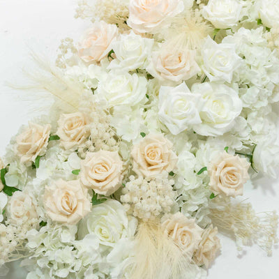 Cream and white roses floral arrangement with delicate feathers and hydrangeas