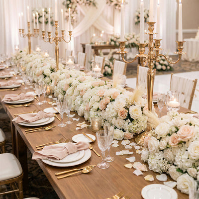 Elegant wedding reception table with floral centerpieces and gold candleholders