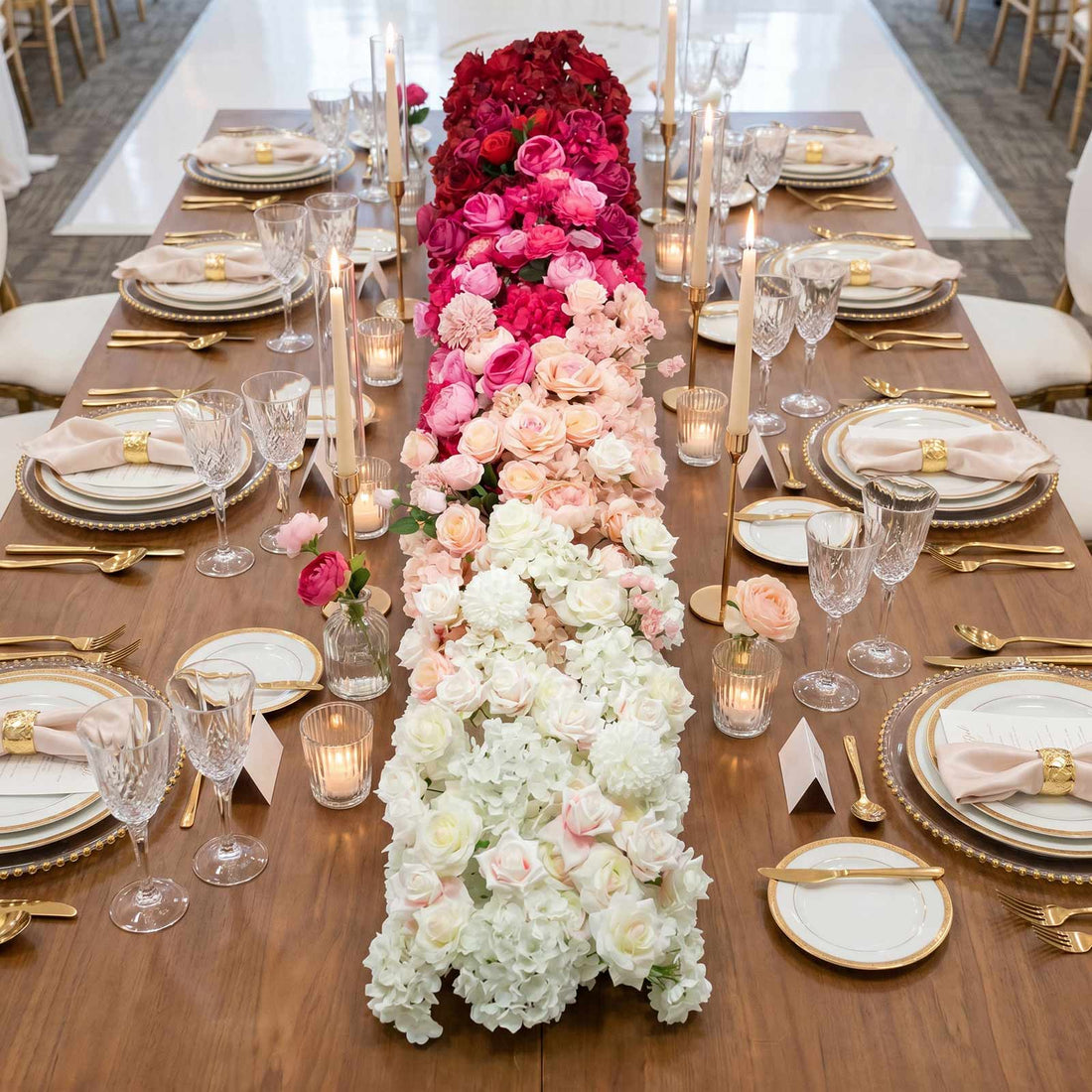 Elegant floral wedding table centerpiece with pink and white roses and gold tableware