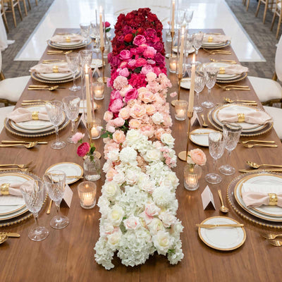 Elegant floral wedding table centerpiece with pink and white roses and gold tableware