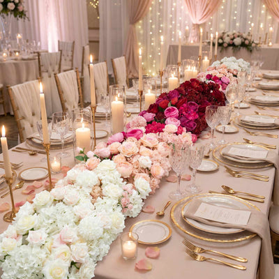 Elegant blush wedding reception table with flowers, candles, and gold tableware