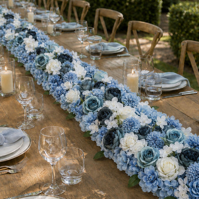Elegant outdoor dining table with blue floral centerpiece and candles