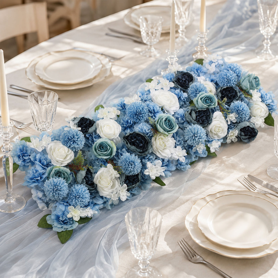 Elegant blue floral wedding table centerpiece with crystal glassware and candles