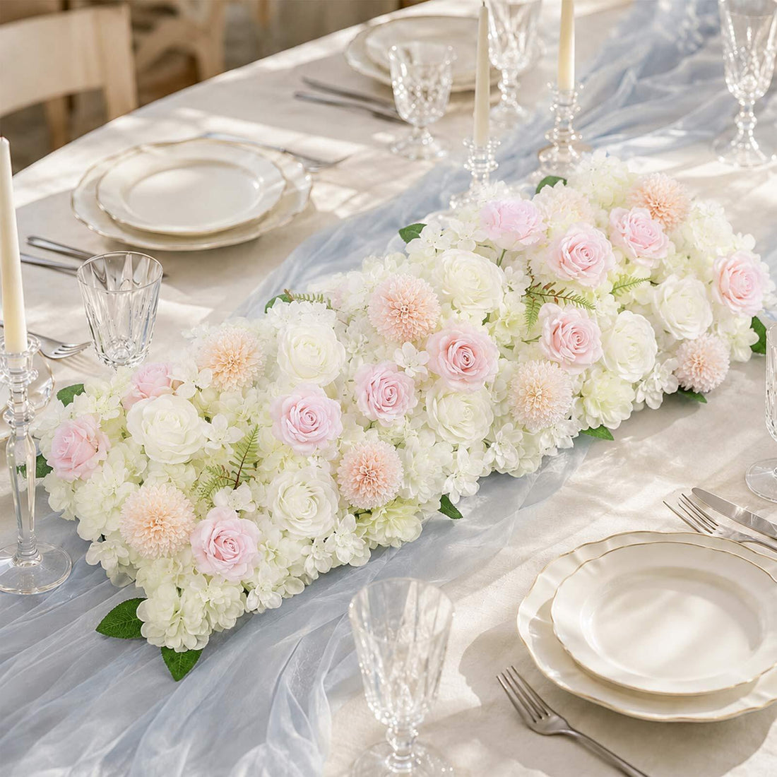 Elegant pastel wedding table centerpiece with roses, hydrangeas, and candles