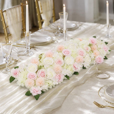 Elegant pastel floral table runner with candles on a wedding reception table