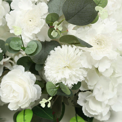 White silk flowers with eucalyptus leaves in a soft floral arrangement