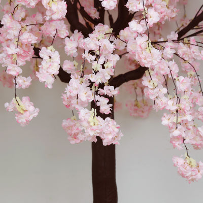 Artificial cherry blossom tree with pink flowers and brown trunk.