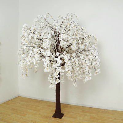 Artificial white cherry blossom tree on a plain backdrop