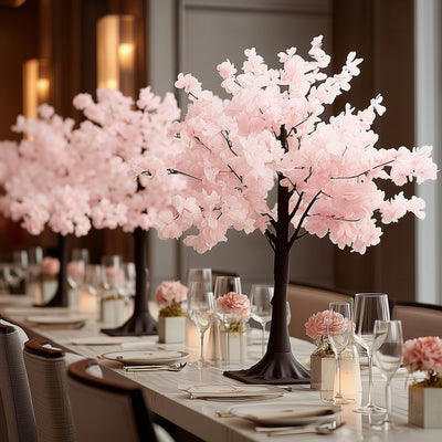 Pink cherry blossom table centerpiece in elegant dining setting.