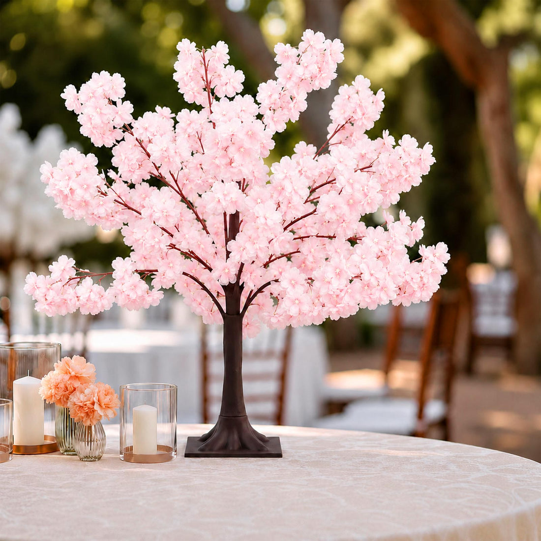 Pink cherry blossom centerpiece with candles on a wedding table