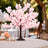 Pink cherry blossom centerpiece with candles on a wedding table