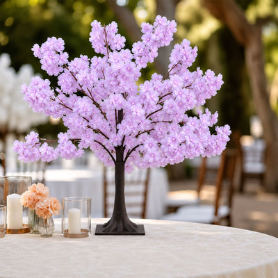 Pink cherry blossom tree centerpiece with candles on an outdoor table
