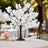 White cherry blossom tree centerpiece with candles on an elegant table