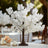 White floral tree centerpiece for elegant table decor.