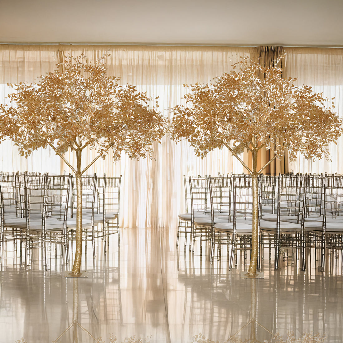 Decorative gold leaf trees in an elegant event space with chairs.