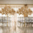 Decorative gold leaf trees in an elegant event space with chairs.