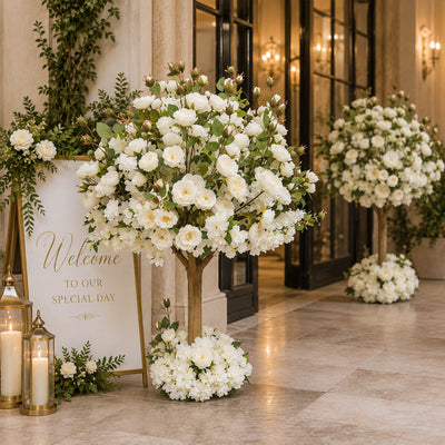 Elegant wedding entrance with white floral arrangements and welcome sign