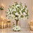 Elegant white floral tree centerpiece with candles in a wedding setting