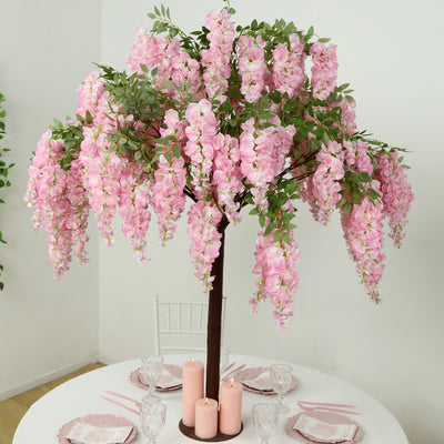 Artificial pink flower tree centerpiece for elegant table decor.
