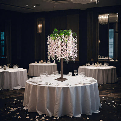 Elegant floral centerpiece on round dining table in a sophisticated event setting.