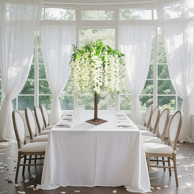 Elegant floral centerpiece on a dining table in a bright, airy setting.