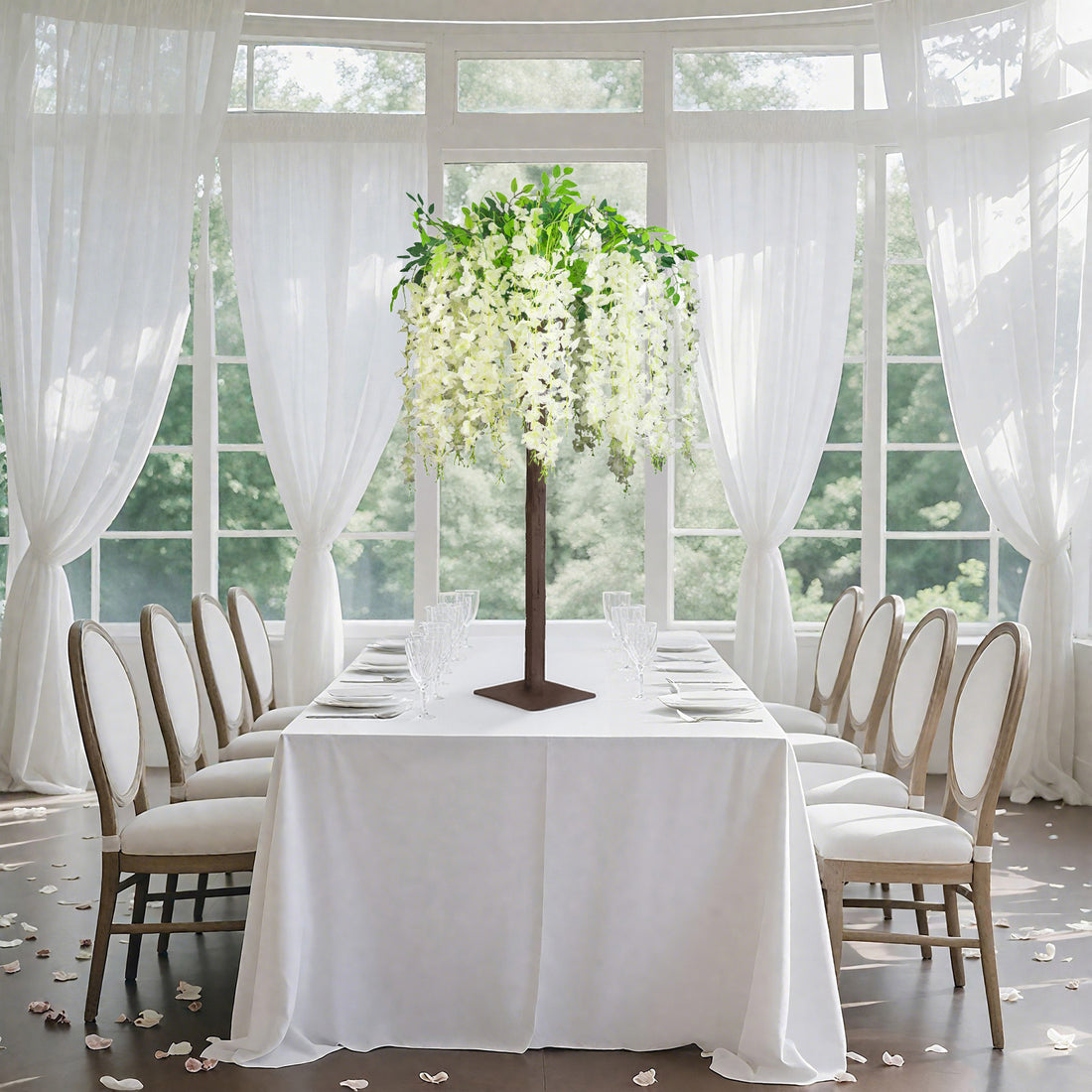Elegant floral centerpiece on a dining table with white drapes and soft lighting.