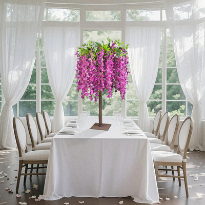 Artificial flower tree centerpiece for elegant dining setup.
