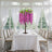 Elegant purple floral centerpiece on a dining table in a bright, airy setting.