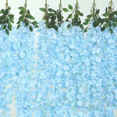 Blue artificial flower garland with green leaves, perfect for decorations.