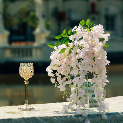 Elegant faux flower arrangement with a decorative glass candle holder.