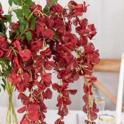 Red artificial flower garland with cascading blooms for home decor.