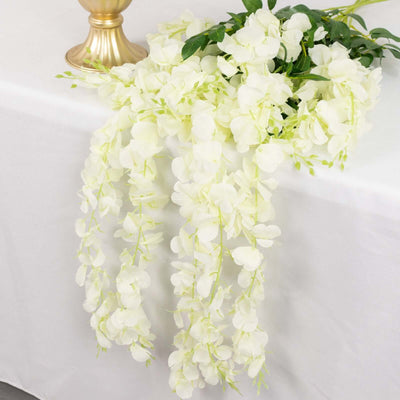 Artificial white orchid flower garland with green accents.