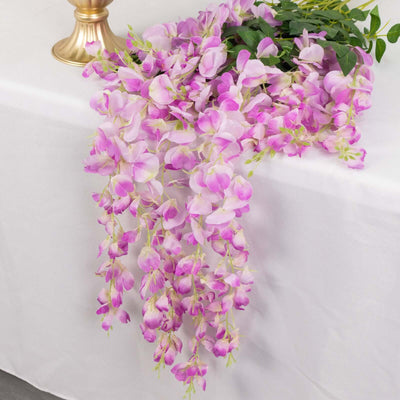 Purple orchid flower arrangement cascading elegantly on a table.
