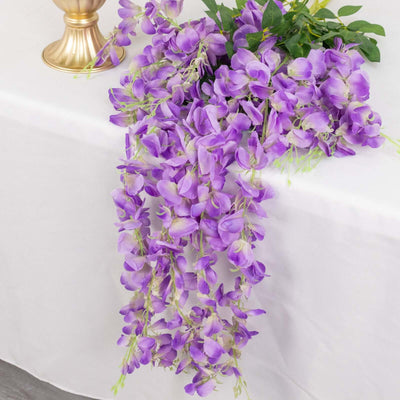 Purple wisteria flower garland cascading over a table.