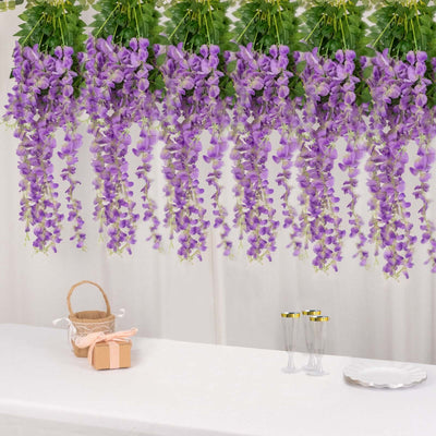 Purple wisteria flowers hanging decoratively above a table setting.