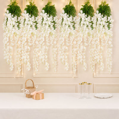 Elegant white floral wall decor with champagne glasses and gift boxes on a table