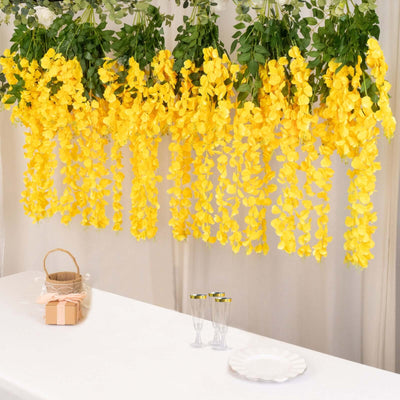 Yellow flower garland decoration hanging above a table with glasses and a basket.