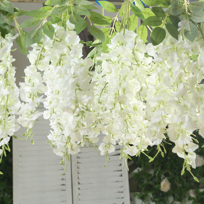 White floral hanging decor with lush greenery