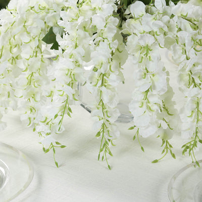 White wisteria floral arrangement in a clear vase.