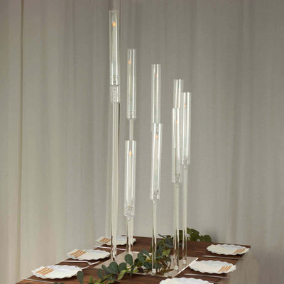 Elegant glass candle holders in varying heights on a beautifully set table.