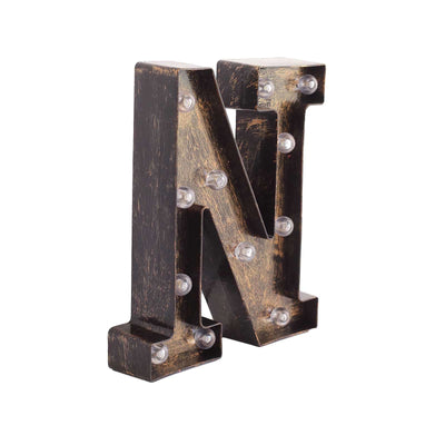 Vintage marquee letter "N" with lights on a plain background.