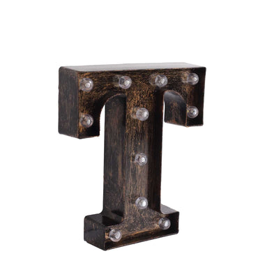 Rustic marquee letter "T" with LED lights on a plain background