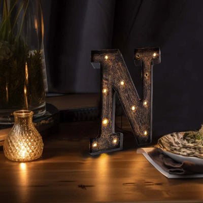 Decorative light-up letter "N" in rustic style on a table setting.