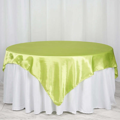 Round green satin tablecloth on a white table.