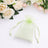 Green organza gift pouch with floral roses on white fabric background