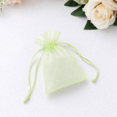 Light green organza drawstring gift pouch with flowers on white background
