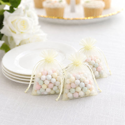Pastel candy in organza gift bags on a white table setting