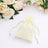 Cream organza drawstring gift bag with white roses on a soft background