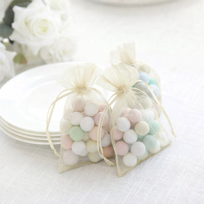 Pastel colored candy-filled organza bags on a table